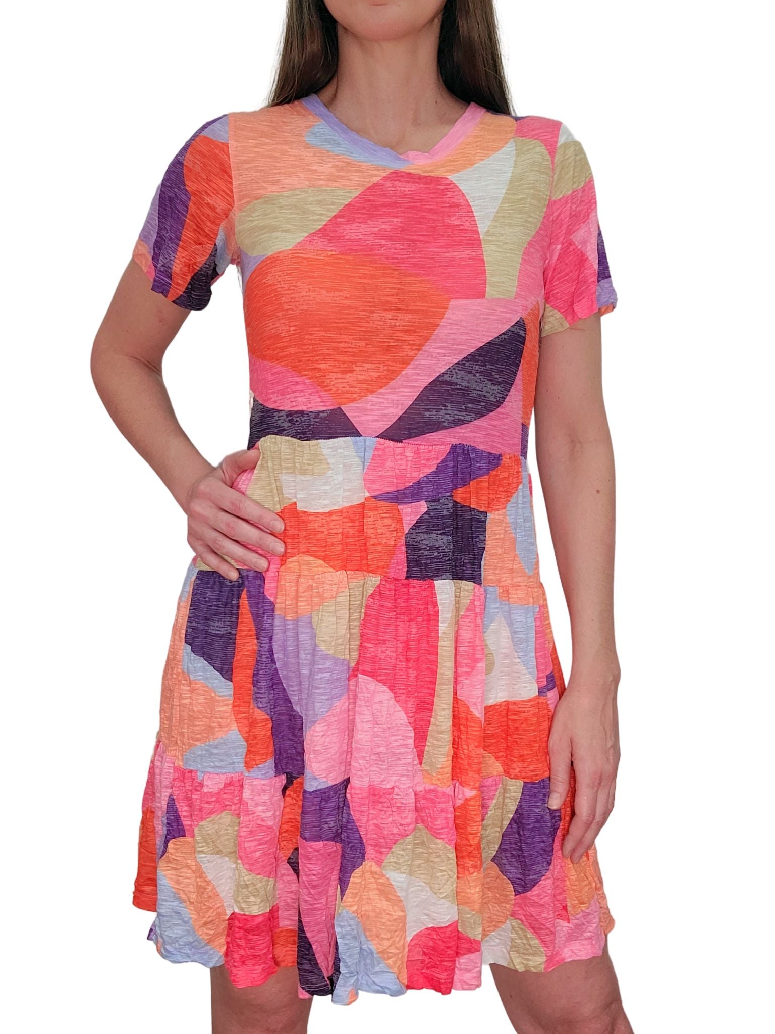 Women's casual tiered babydoll mini dress with short sleeves - bold abstract pattern in sunset orange, cobalt blue, true purple, rich eggplant, cool beige, hot pink, peach, pale blue and white. Perfect for vacation outfits or effortless day-to-day summer style